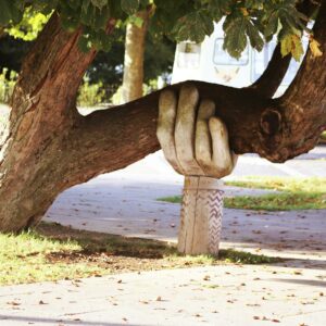 Arbre soutenu par une sculpture en forme de main géante - soutien sarah